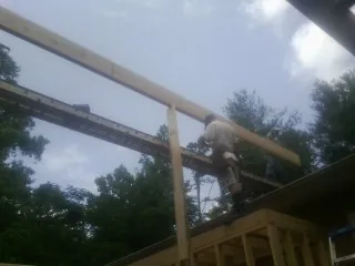 Carpenter setting a ridge beam over a new addition frame — Ice Dam Removal by Roofing Brothers in Gnadenhutten