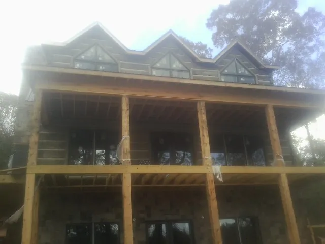 Dormers and porch framing on a large log home under construction — Roof Coating work by our crew in Gnadenhutten