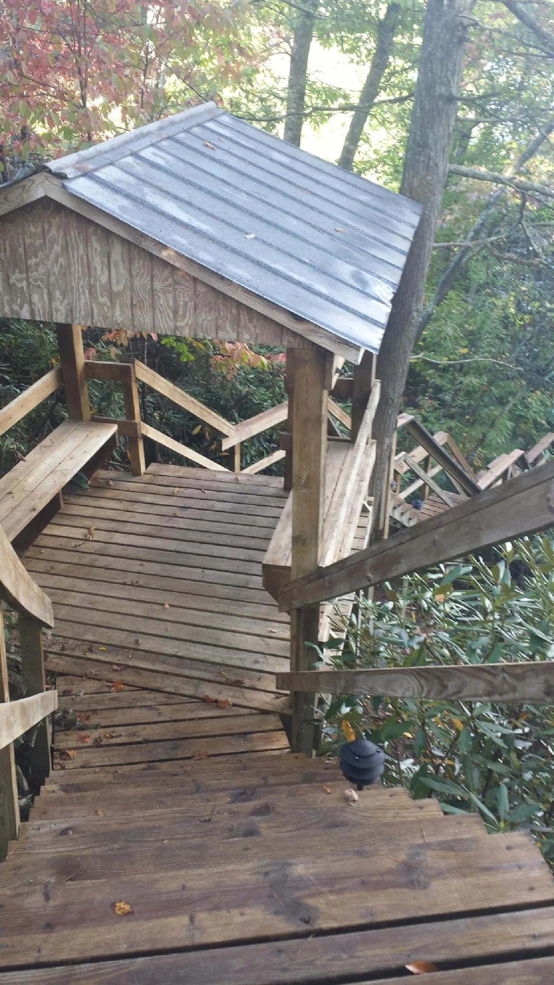 Metal roofed shelter over wooden steps on a wooded walkway — Skylight Repair & Installation work by our crew in Gnadenhutten