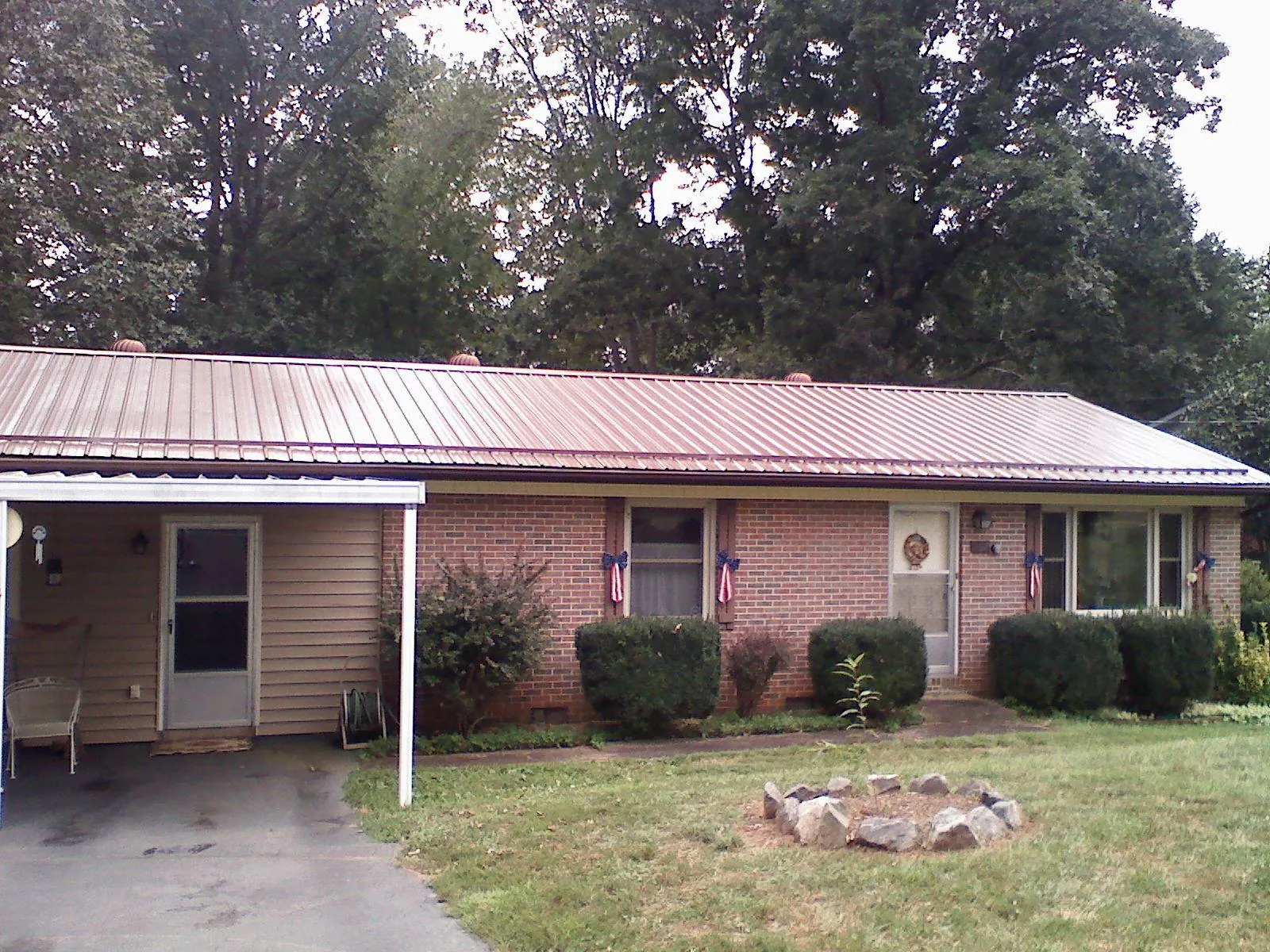 Bronze metal roof and carport on a brick ranch home — Roof Repair work by our crew in Gnadenhutten