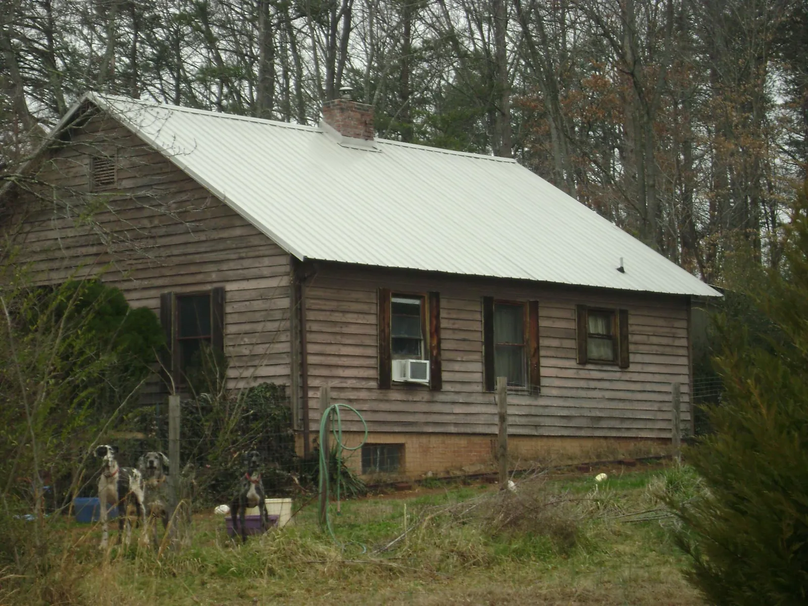 White metal roof on an old wood sided farmhouse, from a Metal Roof Installation job in Gnadenhutten